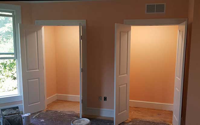 Two open closets have been recently remodeled.  There is white trim and the room is painted a peach color.